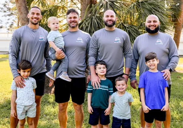 The Native Sons Roofing team standing together with their sons, smiling for a group photo.